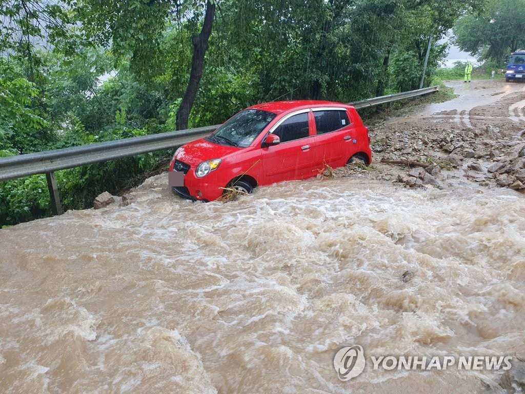 8月3日，在京畿道加平郡加平邑金垈裡，車輛在“泥浪”中艱難前進。