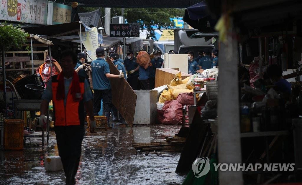 韓國慶尚南道地區遭遇強降水。當地警察出動，前來支援受災嚴重的花開市場。