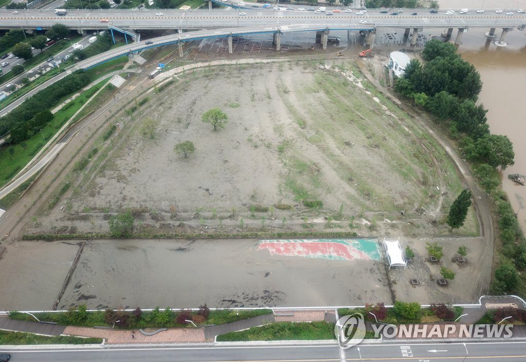 8月12日，在韓國首爾廣渡口漢江公園，地面上的積水褪去，露出淤泥。