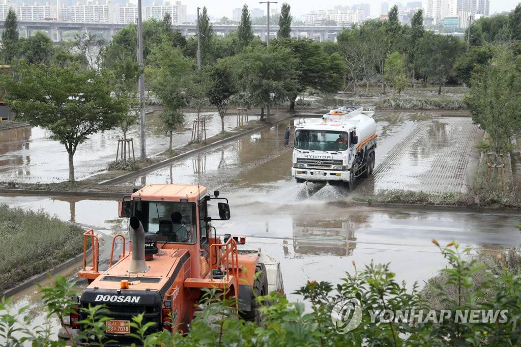 8月12日，在盤浦漢江公園，漢江事業本部的工作人員正在使用重型機械進行清理工作。