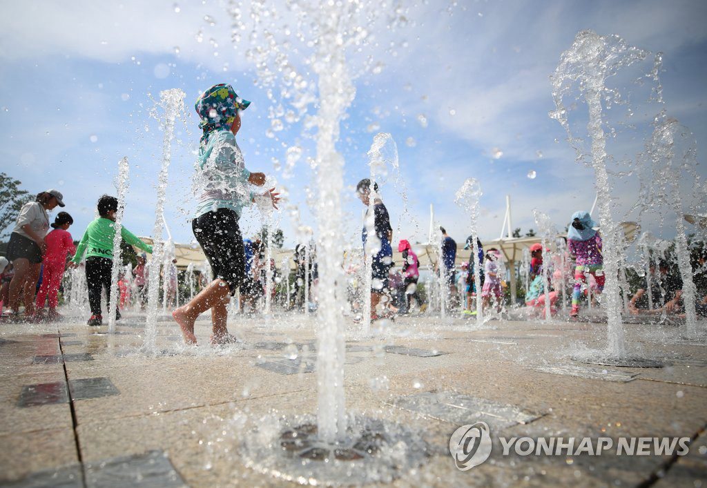 8月17日上午，在庆尚北道庆山市三圣贤历史文化公园，小朋友们正在喷泉池戏水降温。