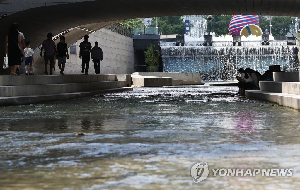 8月17日下午，在首爾中區，市民從橋底下穿過納涼。