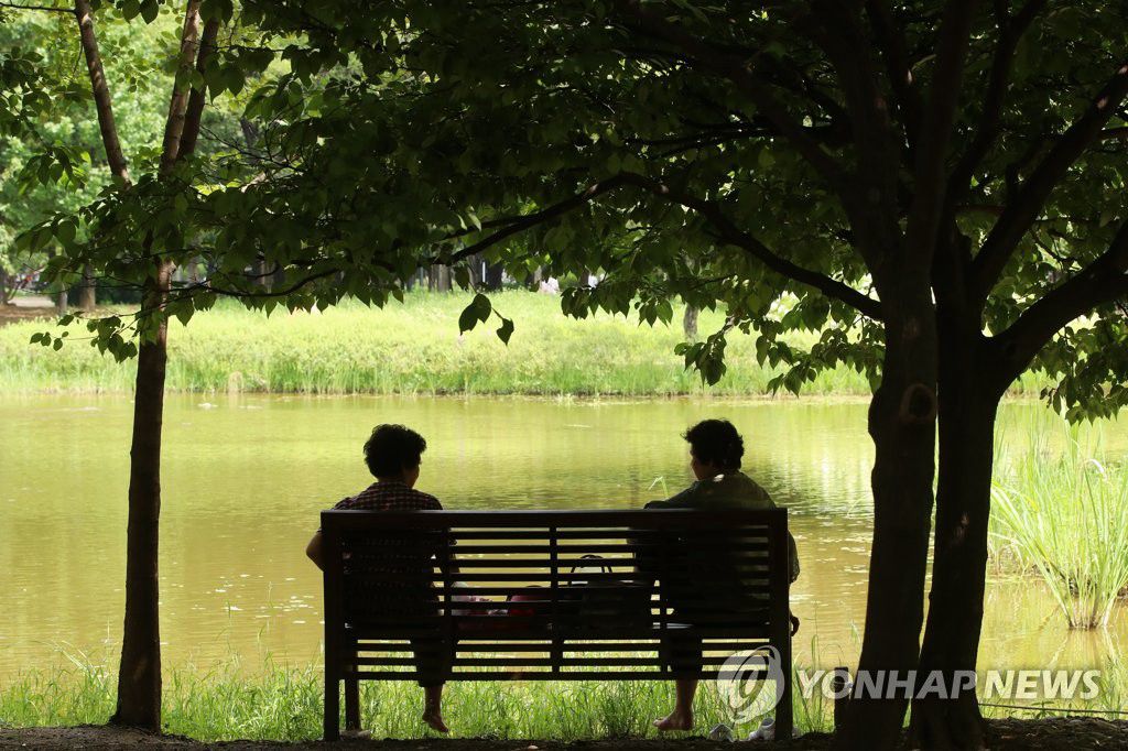 8月17日下午，在首爾城東區首爾林公園，市民們坐在樹蔭下的涼椅上休息。