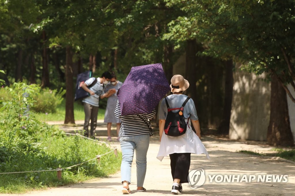 8月17日下午，在首爾城東區首爾林公園，市民們做好防晒措施來此散步。