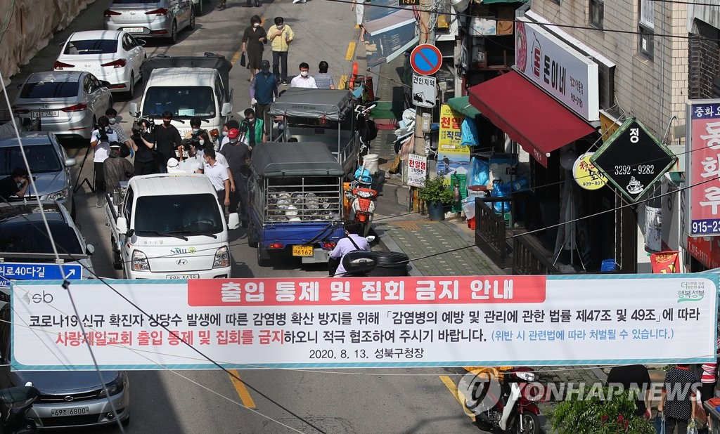 18日下午，在首爾城北區“愛第一教會”附近，商家、居民、公務員等正在街道上進行消毒作業。