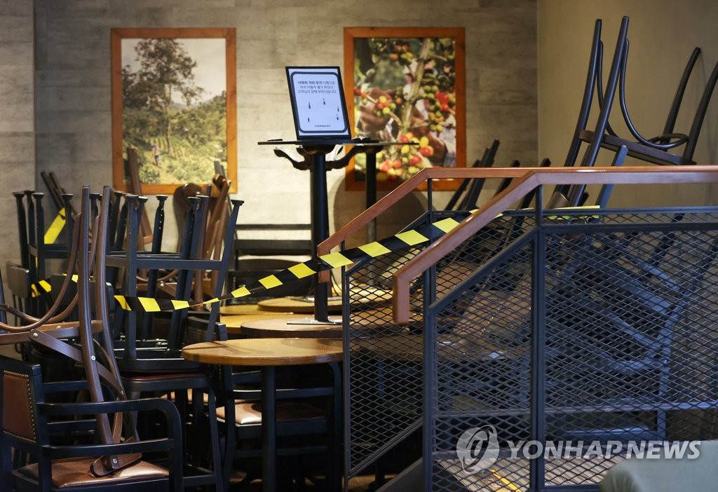 18日下午，首爾中區一家星巴克，為遵守保持“社會距離”措施，將部分桌椅封存。
