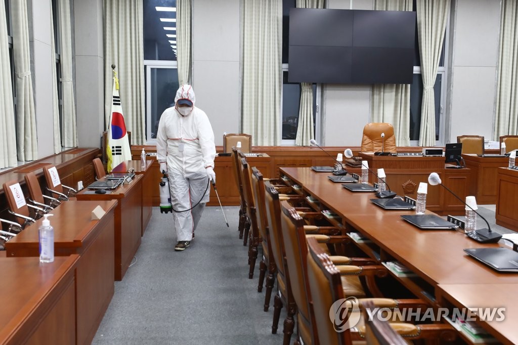 27日，在韩国国会议事堂运营委员会会议厅，防疫工作人员正在进行消杀工作。