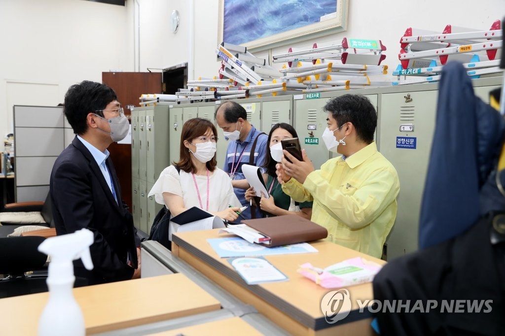 27日，在韩国国会主楼摄影记者室，流行病学调查组人员正在跟国会工作人员了解确诊者的活动轨迹。