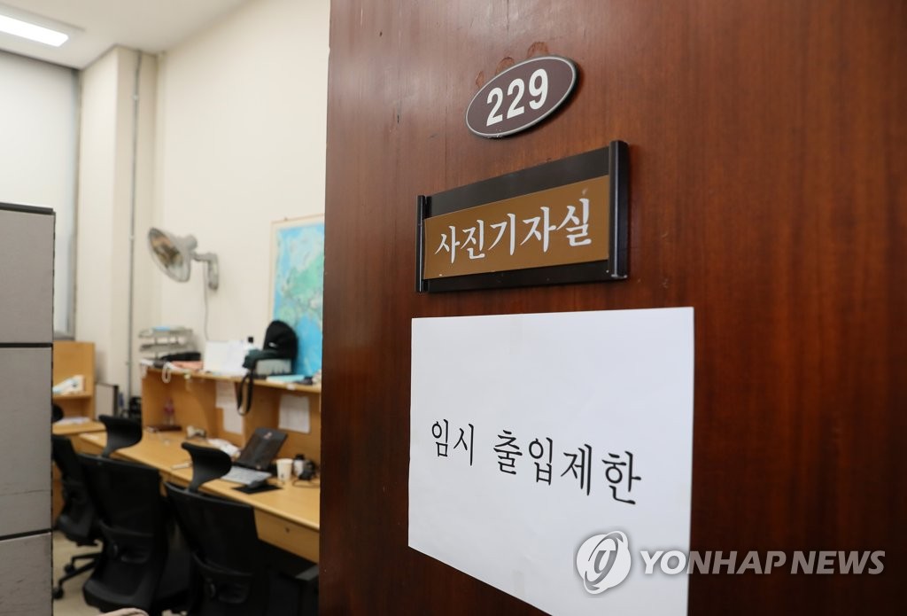27日，防疫工作人员对韩国国会主楼摄影记者室完成消杀作业后，在门上贴上“暂时禁止出入”的提示语。