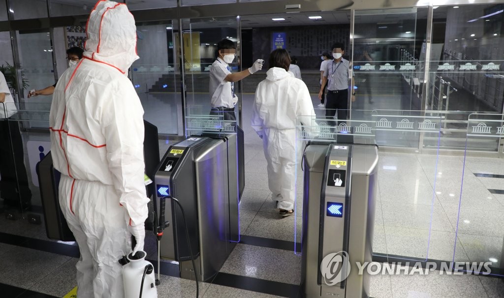 26日晚，防疫工作人员进入韩国国会大楼进行消杀工作。