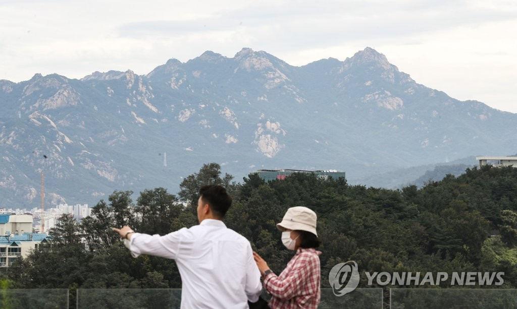 9月6日，市民們在首爾麻浦區的天空公園登高望遠，眺望遠處的北漢山。
