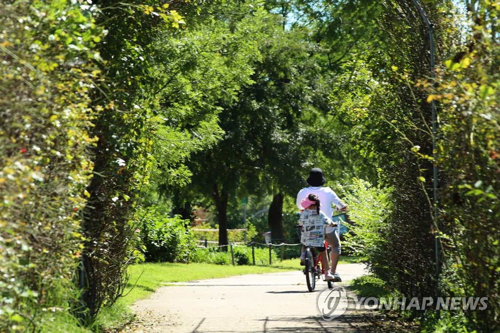 13日，在首爾市汝矣島的漢江公園中，一對母女正在騎自行車。