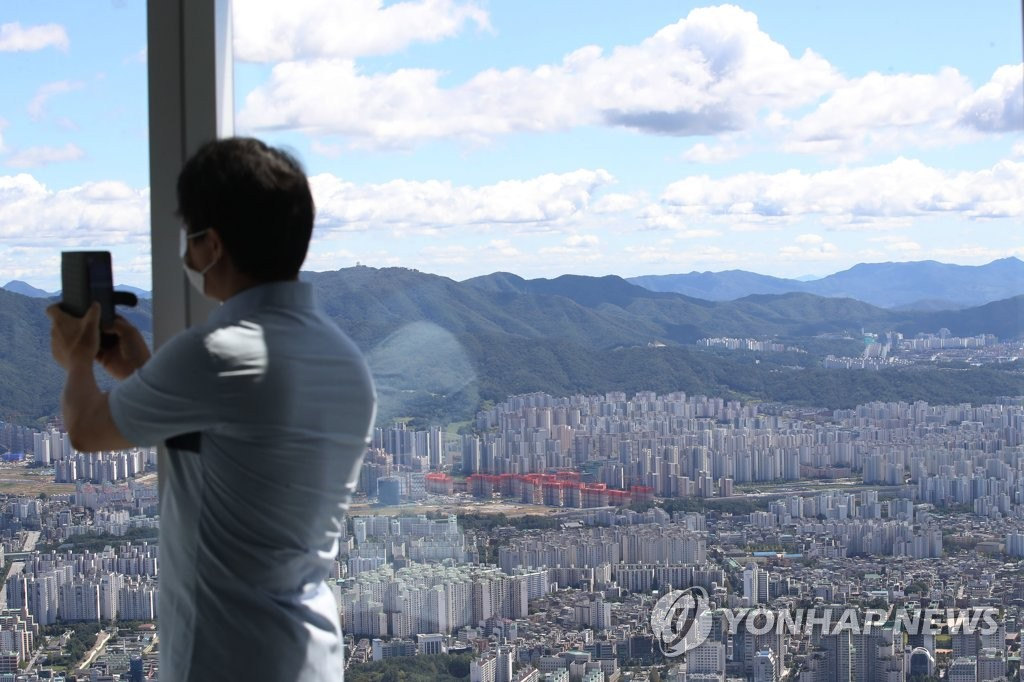 13日，市民在首爾市鬆坡區樂天世界塔上登高望遠，拍照留念。