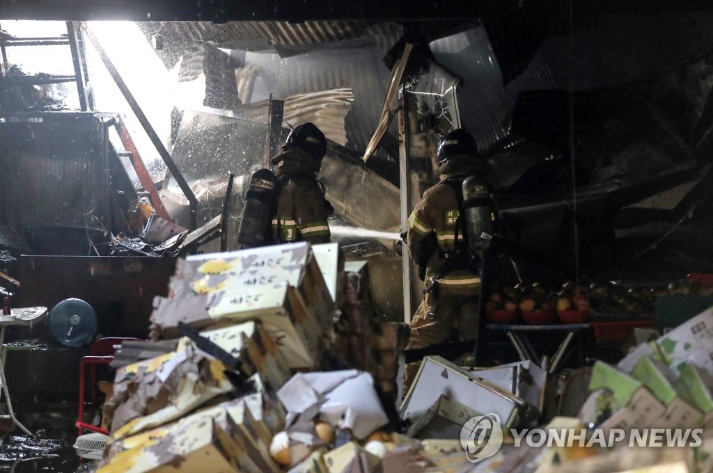 21日凌晨4時30分左右，首爾清涼裡農貿市場發生火災。消防人員正在檢查火災現場。