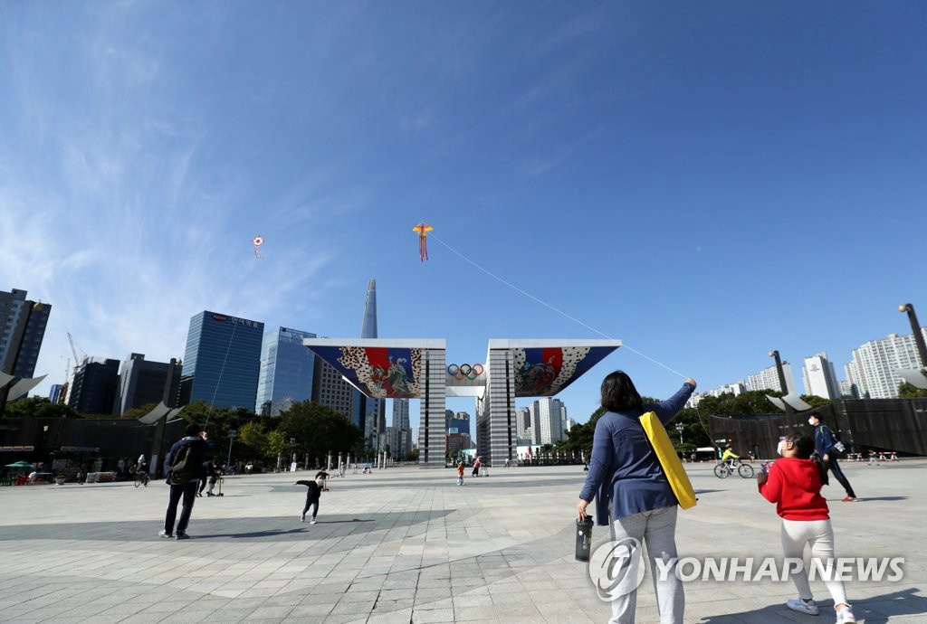 10月9日，在首爾鬆坡區奧林匹克公園內，家長帶著小朋友正在放風箏。