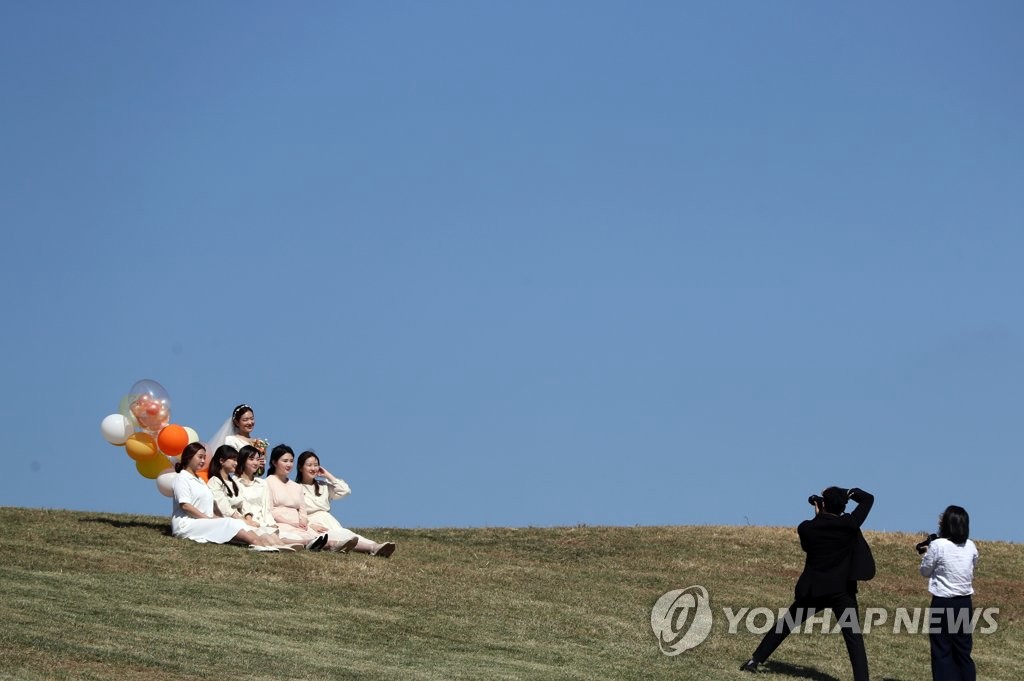 10月9日，在首爾鬆坡區奧林匹克公園內，准新娘和朋友們一起拍照留念。