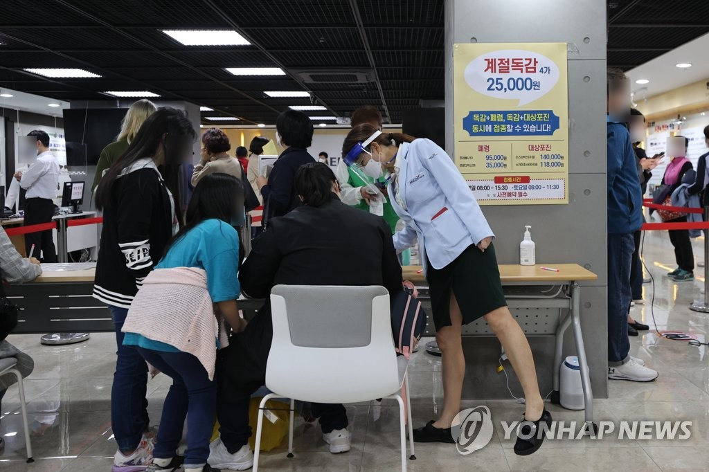 13日，在韓國健康管理協會首爾西部分院內，前來接種的市民正在填寫流感疫苗接種問診表。