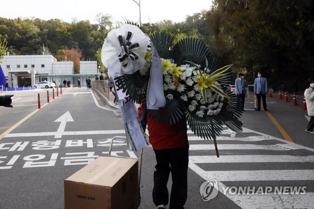 10月25日，韓國外交部長康京和送來吊唁花圈，場地工作人員將其搬運至靈堂。