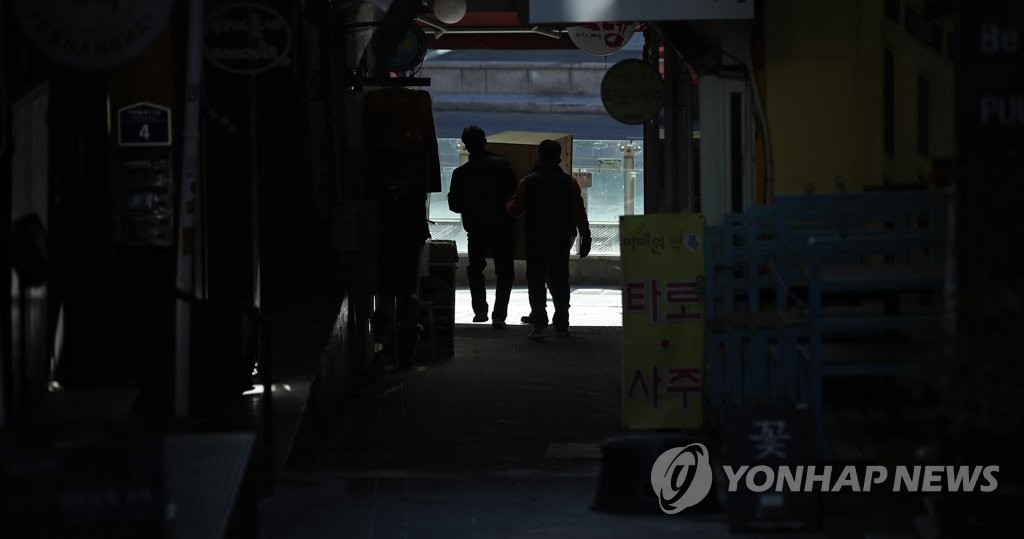 20日，在首爾梨泰院一條小巷裡，一家商鋪工作人員正在搬運家具。