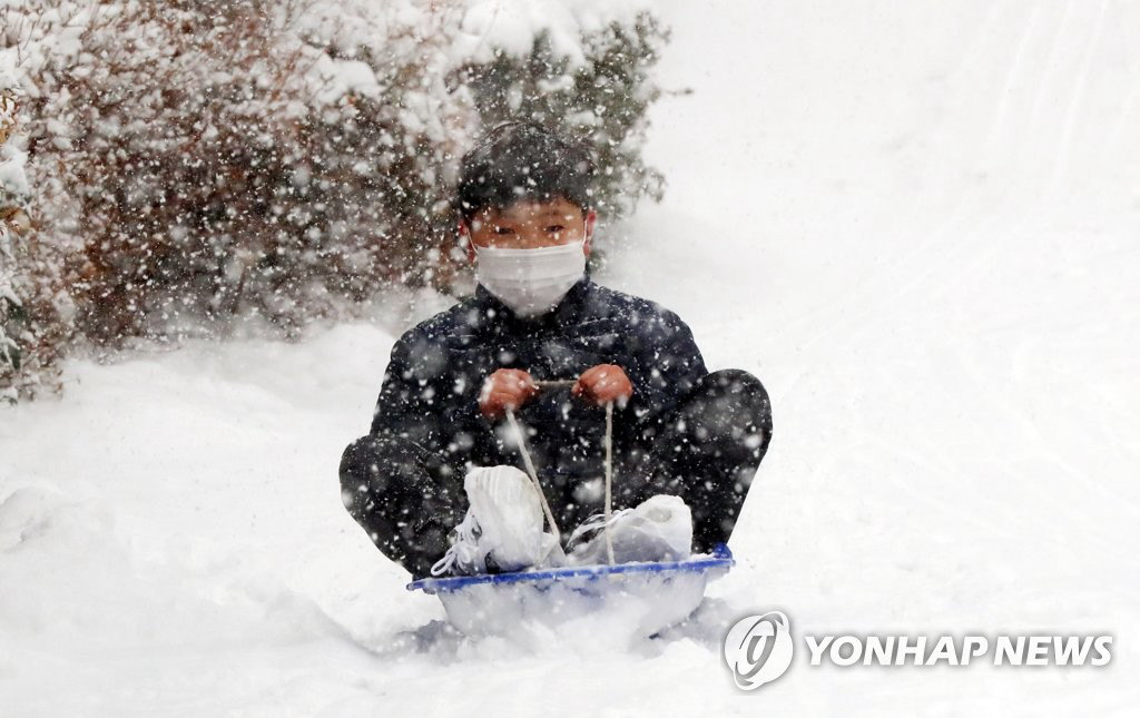 12月30日，在光州北區雲岩洞某小區內的山坡上，一名兒童正在滑雪。