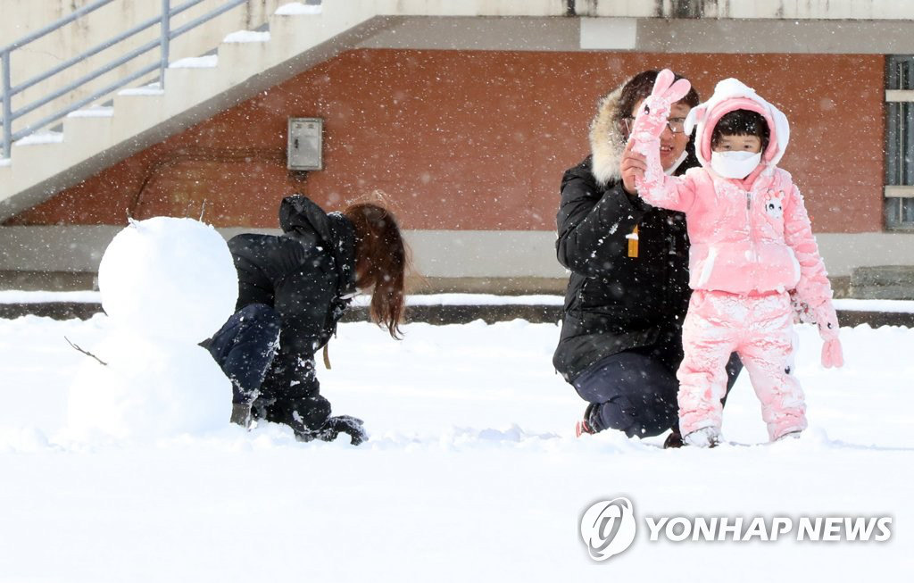 12月30日下午，在光州北區全南大學校園內，一名兒童正在和父母一起堆雪人。