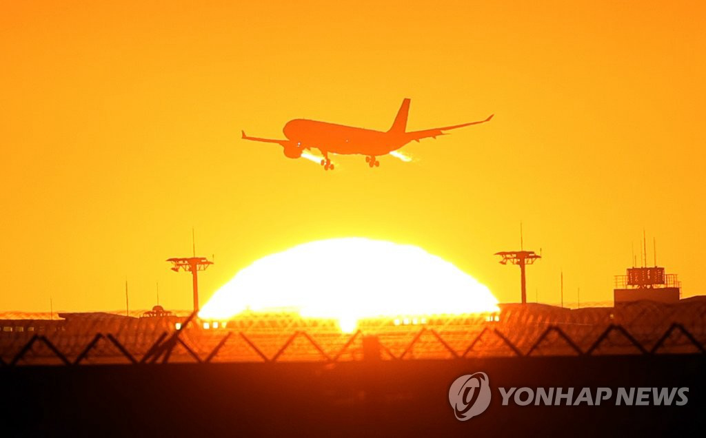 圖為正從仁川國際機場上空緩緩升起的太陽。