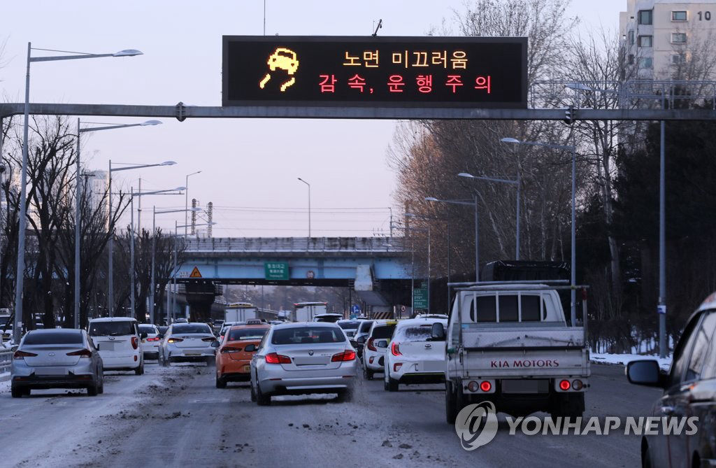 7日上午，6日晚降雪致道路濕滑，首爾奧林匹克大路一電子路牌提醒來往車輛減速慢行。