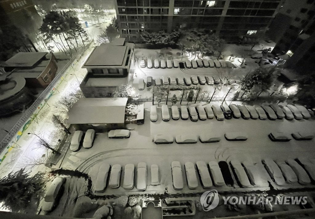 1月18日上午，光州西区一小区停车场白雪皑皑。 