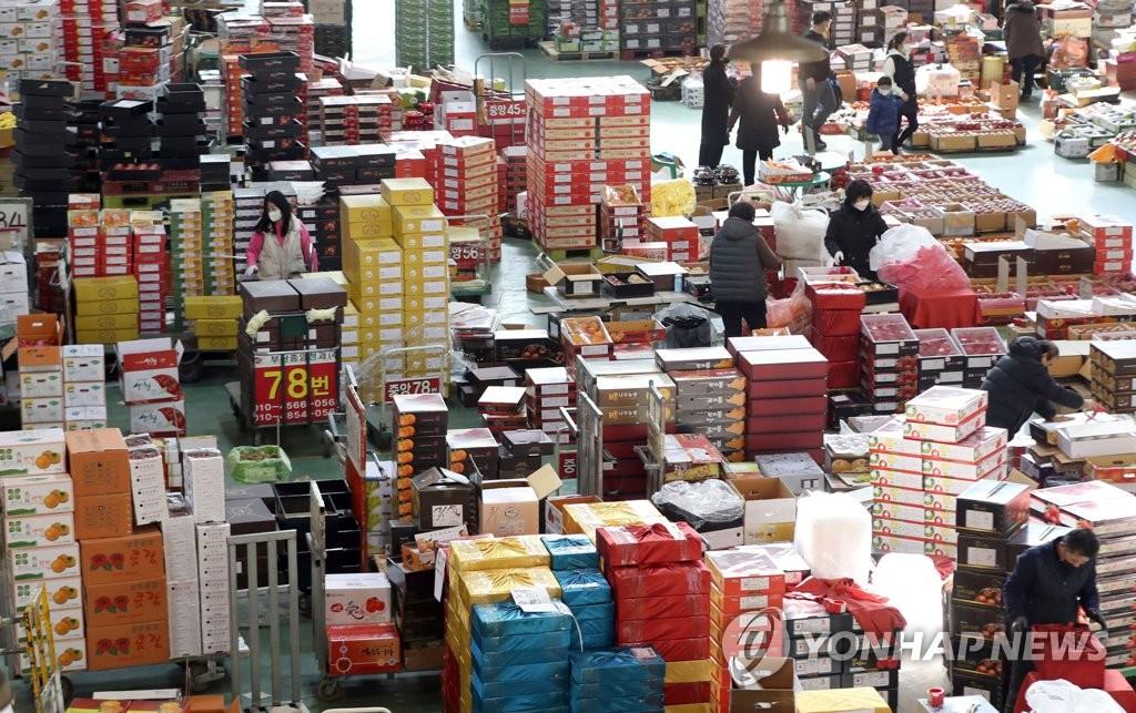 1月31日，釜山市海雲台區一農產品批發市場內，商人們正忙著包裝水果。