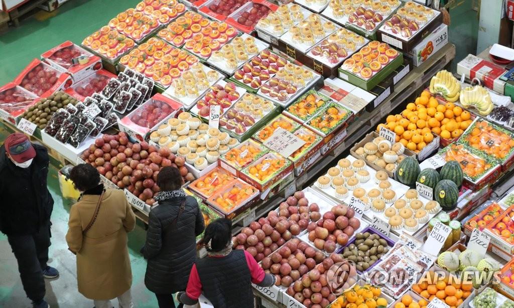 1月31日，釜山市海雲台區一農產品批發市場內，市民們正在挑選水果。