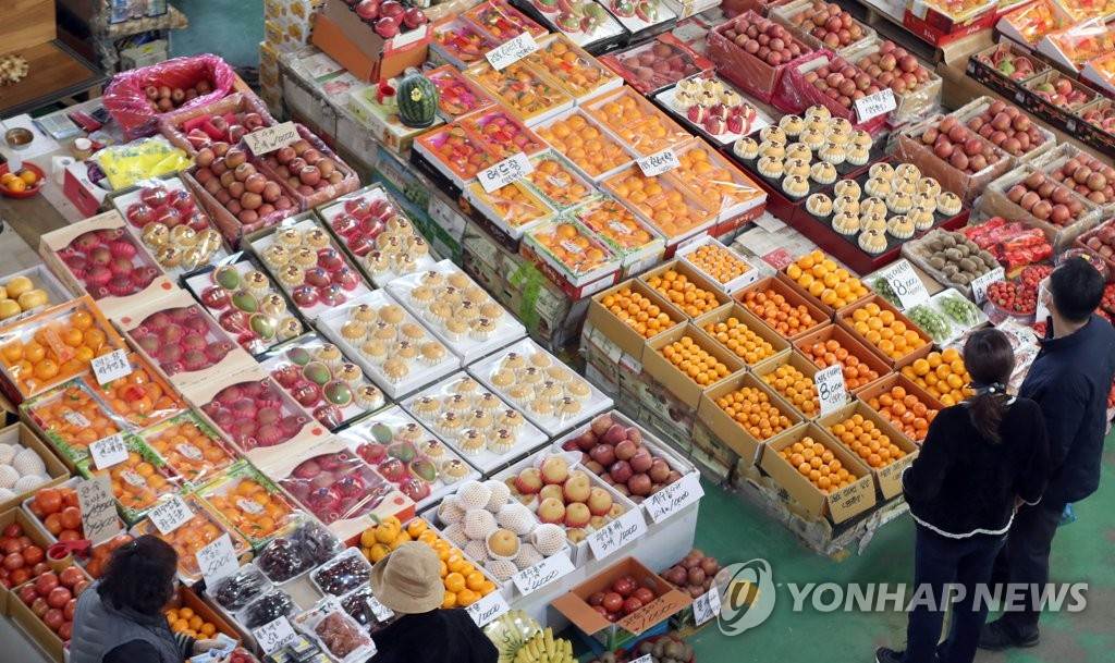 1月31日，釜山市海雲台區一農產品批發市場內，市民們正在挑選水果。