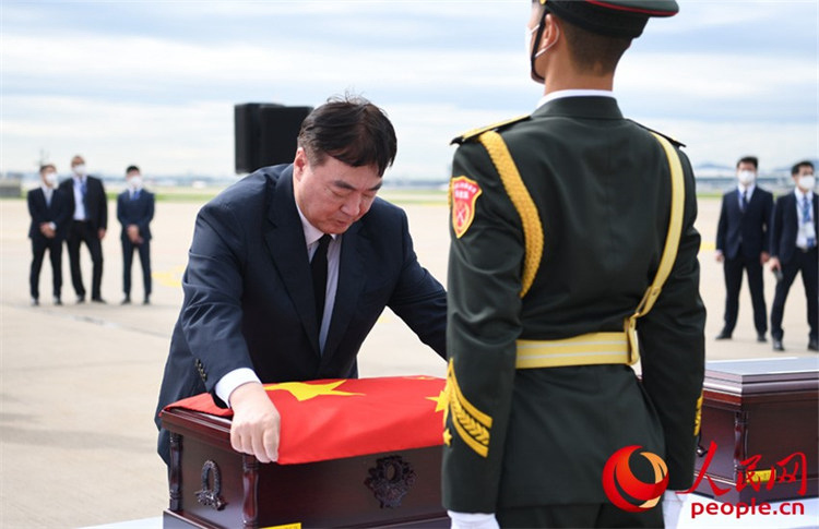 邢海明為志願軍烈士棺槨覆蓋國旗。裴埈基攝