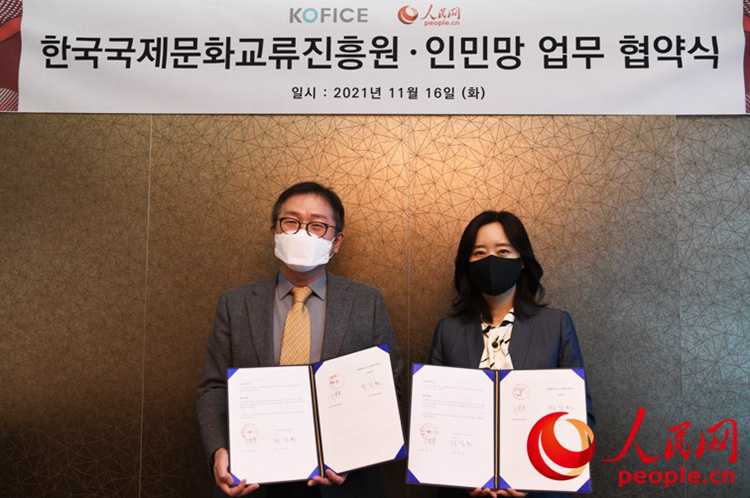 人民網韓國公司總經理周玉波和韓國國際文化交流振興院院長鄭吉（左）和簽約后合影留念。裴埈基攝