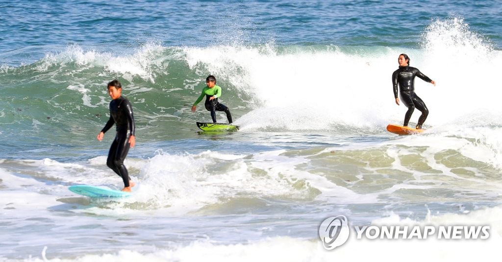 【組圖】韓國冬季海水浴場 沖浪者享受假日