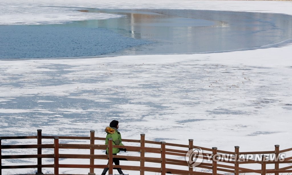12日下午，市民们在清州市兴德区观看结冰的莲堤水库。