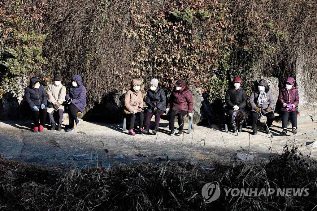 12日，在首尔市西大门区弘济川，市民们正在晒太阳。