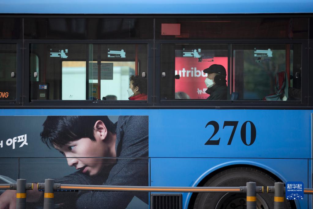 1月18日，人们佩戴口罩在韩国首尔乘坐公交车。新华社记者 王益亮 摄