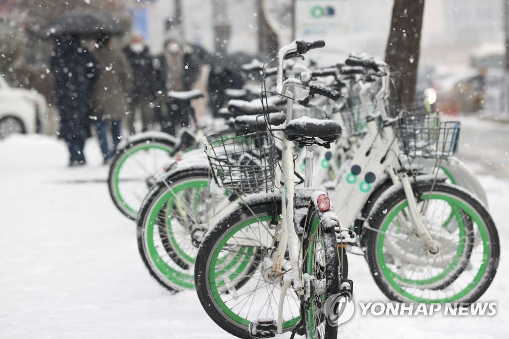 19日上午，首尔市汝矣岛国会议事堂站附近的公共自行车积起了厚厚的雪。