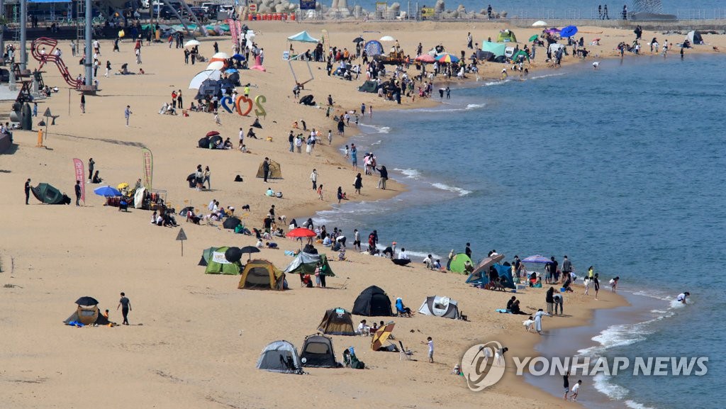 10日，韩国东海岸白天气温大幅上升。在韩国束草海边，市民和游客正享受周末。