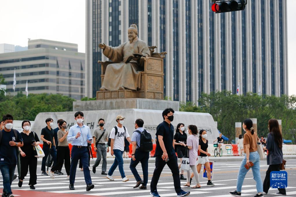8月3日，行人佩戴口罩在韓國首爾光化門廣場過馬路。新華社記者 王益亮 攝