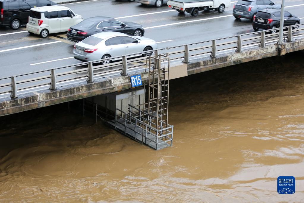 8月9日，车辆在韩国首尔的沿江公路上行驶，旁边是受强降雨影响而水位上涨的汉江。