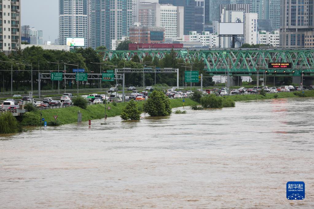 8月9日，车辆在韩国首尔的沿江公路上行驶，旁边是受强降雨影响而水位上涨的汉江。