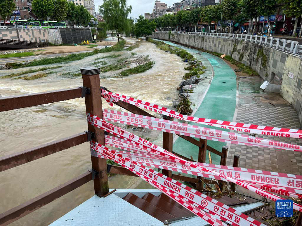 8月9日，受强降雨影响，韩国首尔一条河流旁的人行步道被封闭（手机拍摄）。