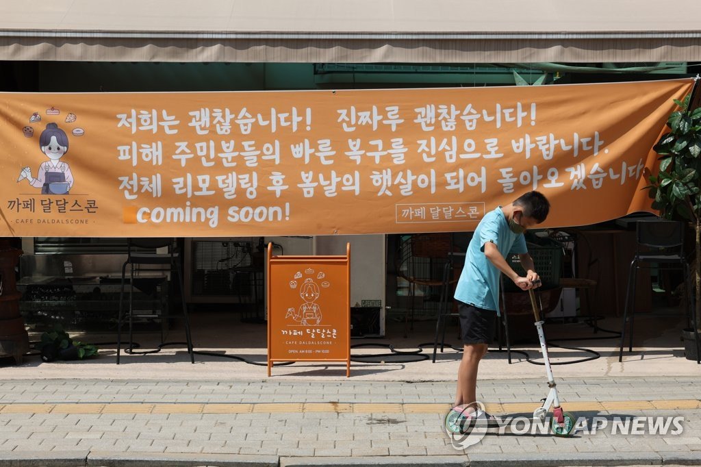 8月12日，首尔冠岳区新林洞的一家咖啡厅悬挂着为灾民们加油助威的横幅。