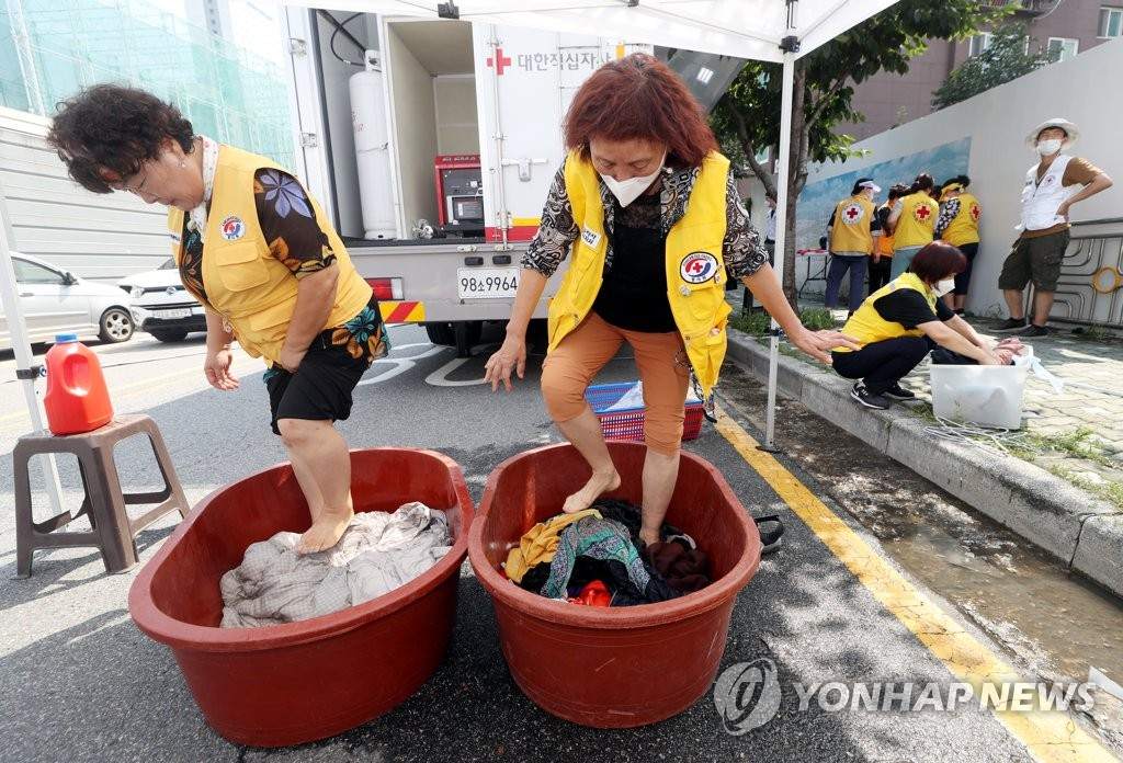 8月12日，仁川市富平區富平洞，大韓紅十字會志願者正在清洗災民的衣服和被褥。