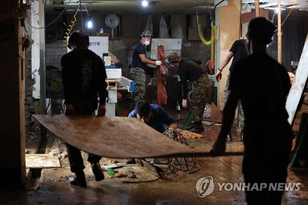 8月12日，在首尔冠岳区新林洞一工厂，韩国军人正在开展灾后重建工作。