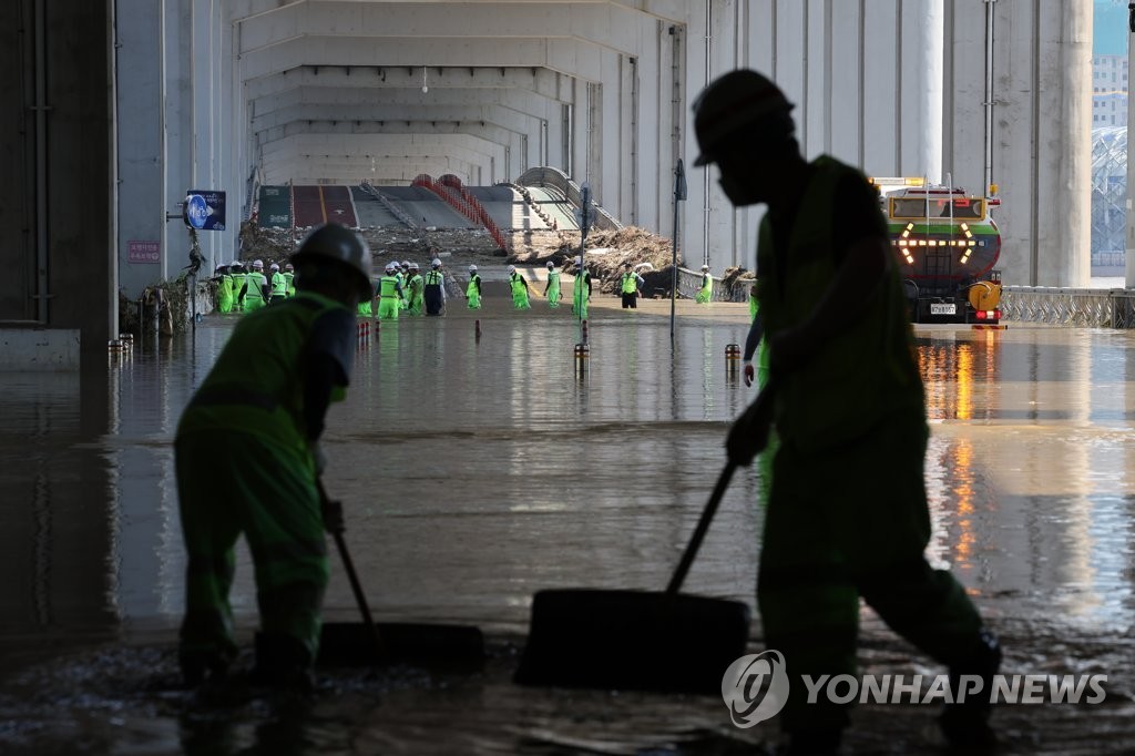8月12日，在首尔潜水桥上，工作人员在为恢复通行进行清扫作业。