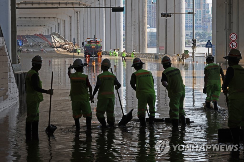 8月12日，在首尔潜水桥上，工作人员在为恢复通行进行清扫作业。