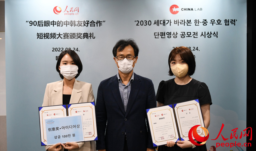 创意奖获奖者金秀贤（左）、夏雪（右）与颁奖嘉宾合影。人民网 裴��基摄