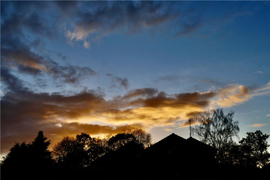 英國牛津郡日落時分 天空透過雲層泛著金色